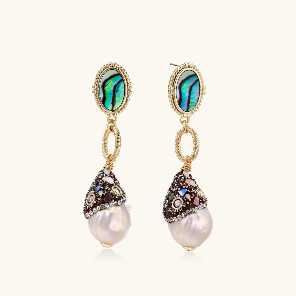 Gold drop earrings with iridescent abalone studs, rope links, jeweled caps and white baroque pearls on cream background