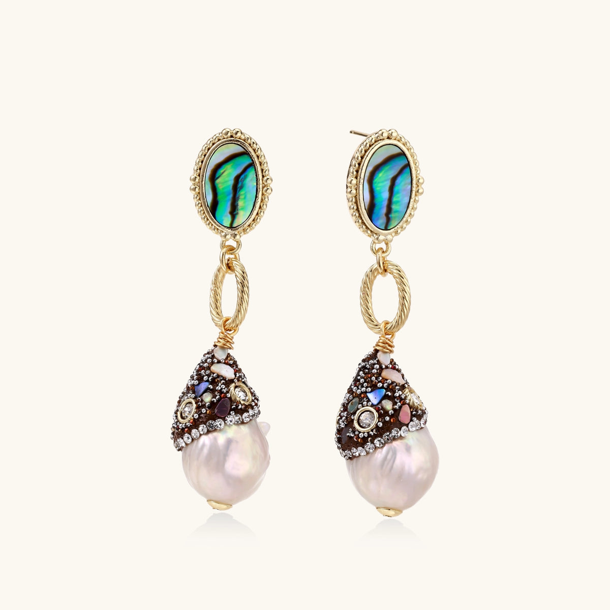 Gold drop earrings with iridescent abalone studs, rope links, jeweled caps and white baroque pearls on cream background