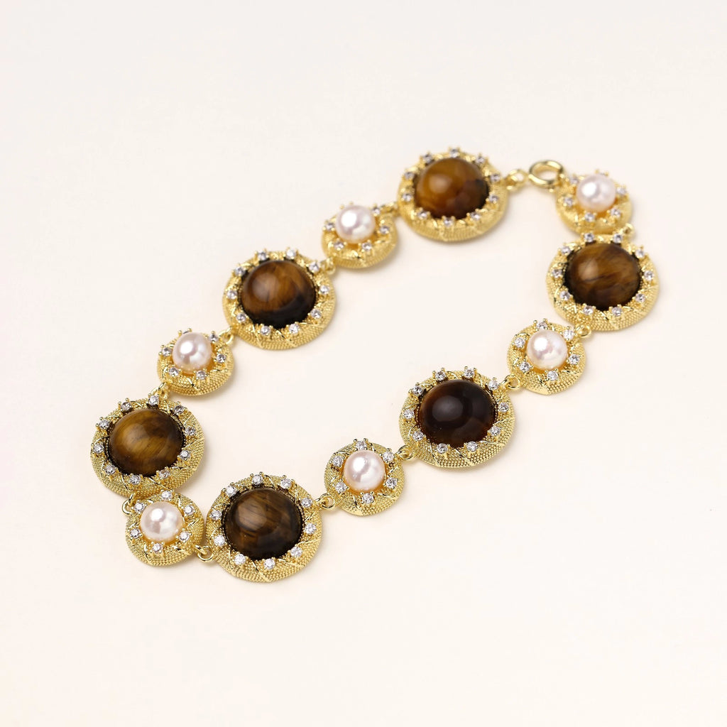 Gold-plated link bracelet with alternating brown tiger's eye stones and white freshwater pearls in ornate bezels.