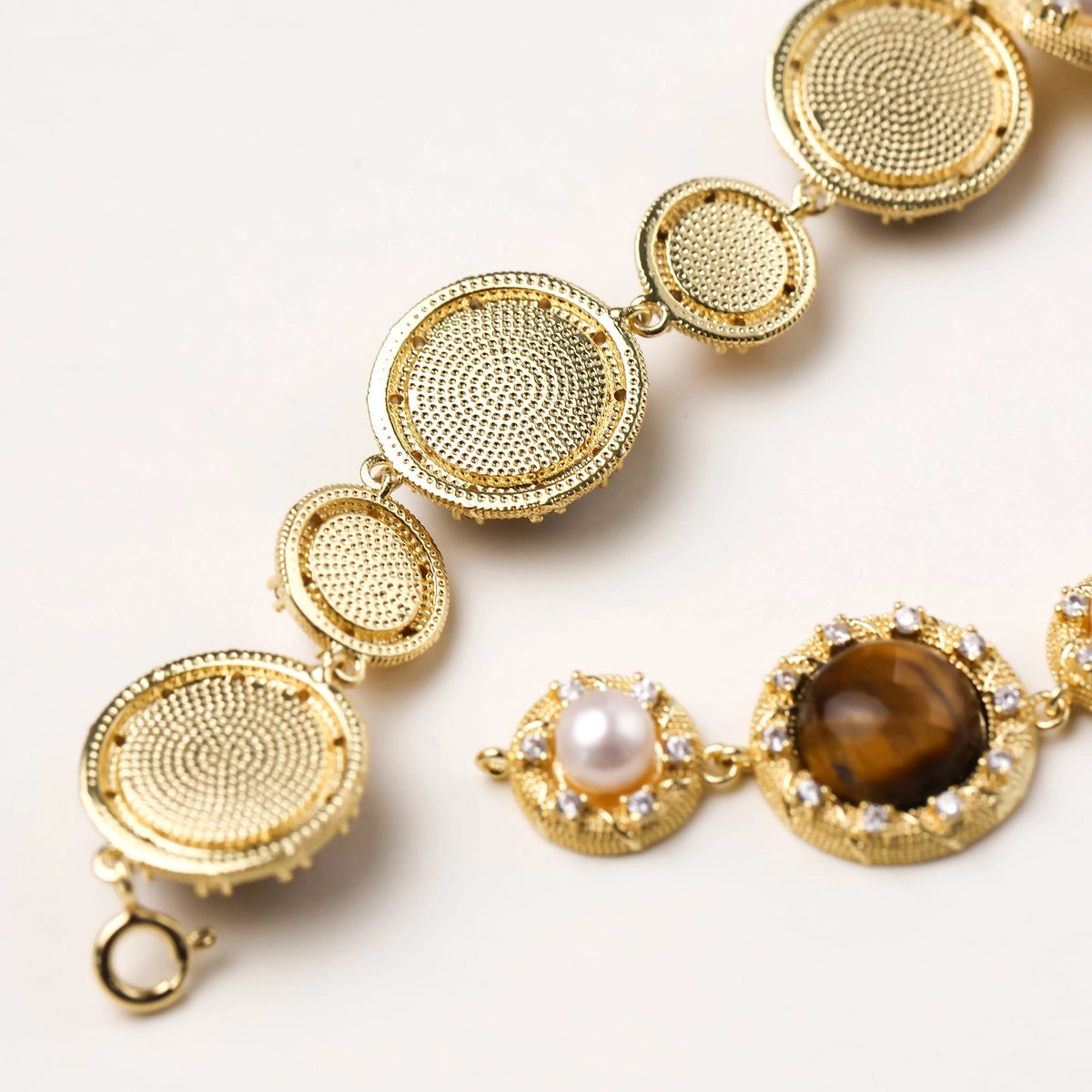 Gold-plated link bracelet with alternating brown tiger's eye stones and white freshwater pearls in ornate bezels.