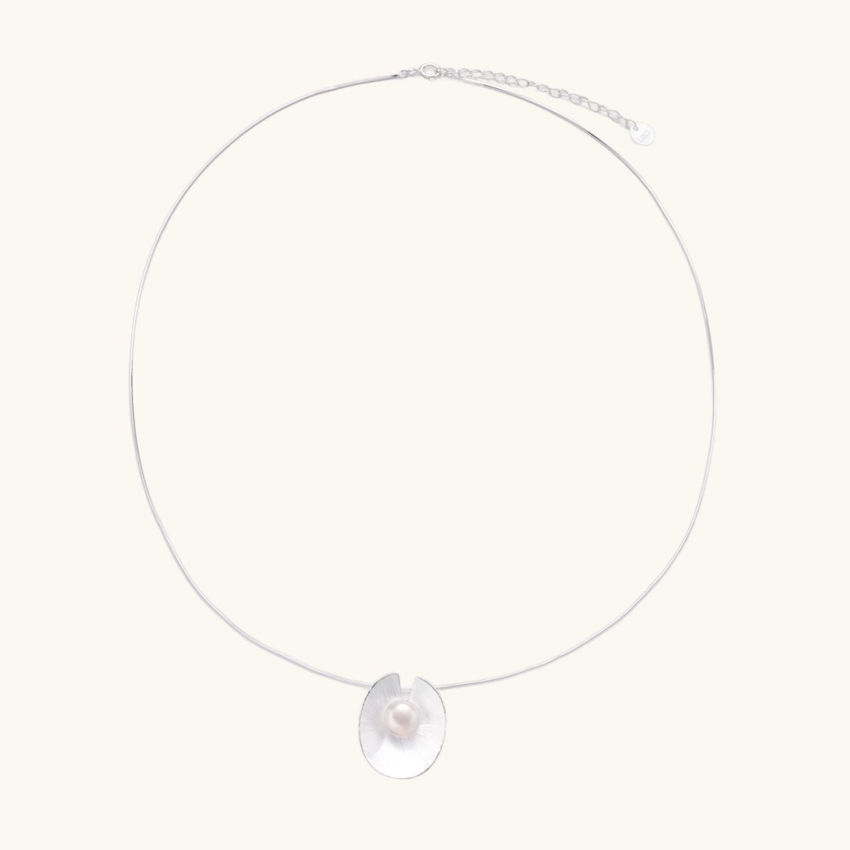Sterling silver disc necklace with textured finish and centered freshwater pearl on delicate chain