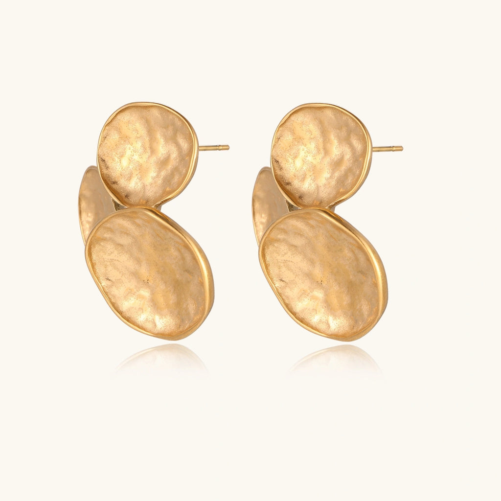 Three hammered gold discs clustered together forming organic statement earrings with textured surfaces